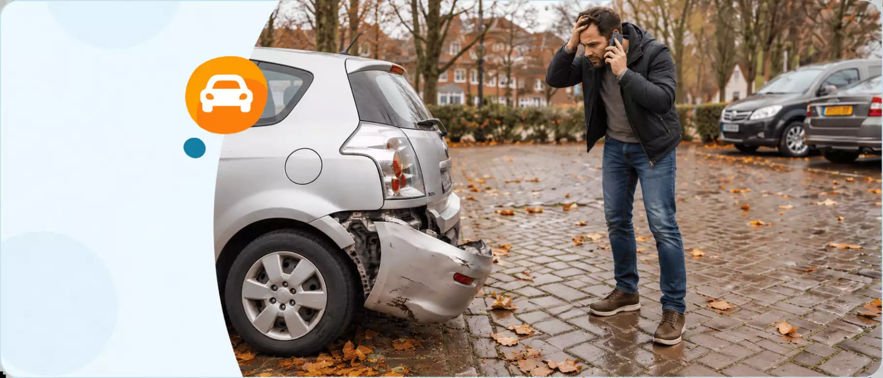 Afbeelding van man die zijn autoverzekering belt terwijl hij naar kapotte auto kijkt