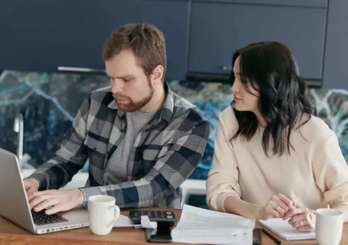 Top 10 goedkoopste energieleveranciers Afbeelding van man en vrouw die energie vergelijken met laptop