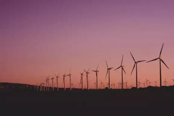 Grootste energieleveranciers van Nederland rij met windmolens tegen ondergaande zon