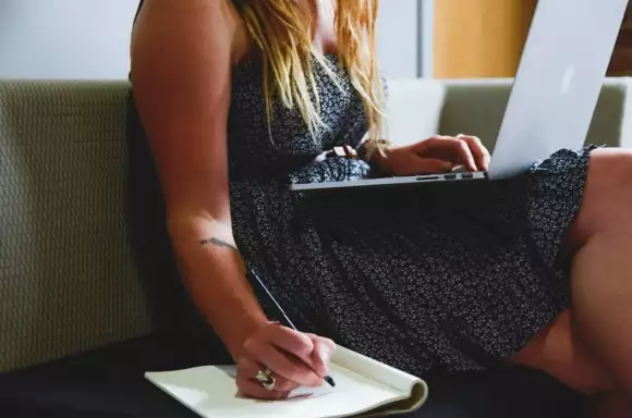 Vrouw werkt op laptop op de bank