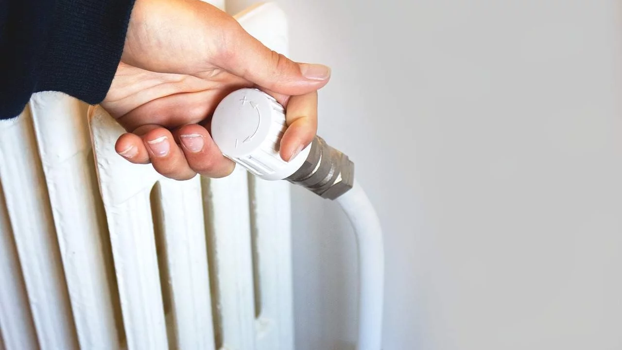 Vrouw draait aan radiatorknop