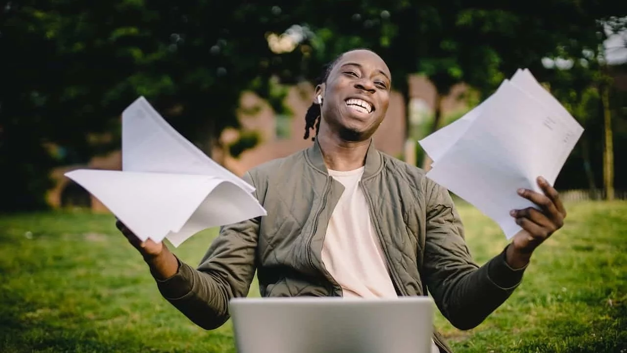 Man lacht achter zijn laptop