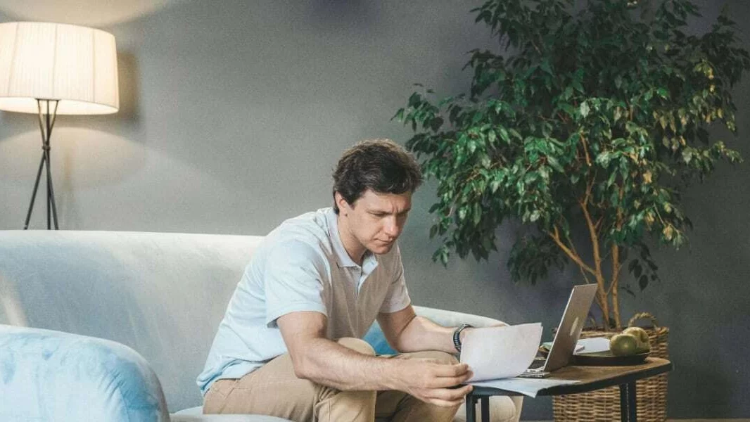 Man bekijkt energierekening achter laptop