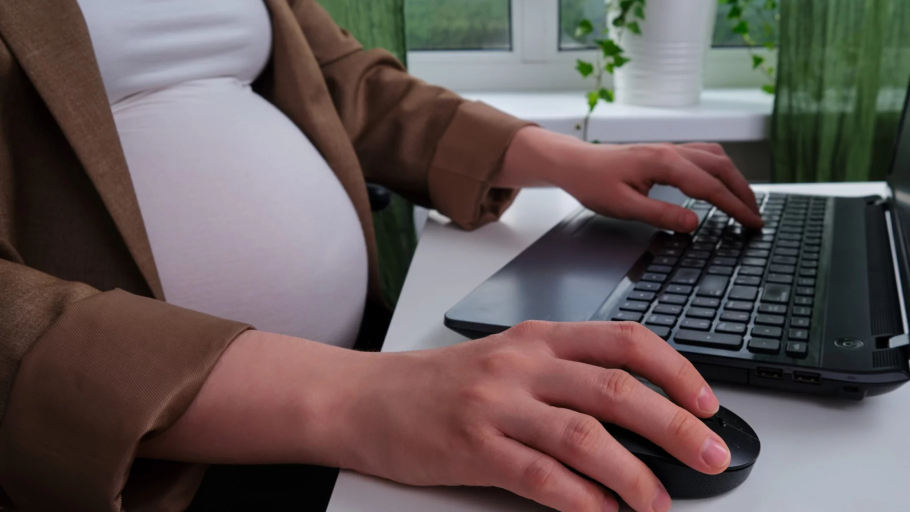 Zwangere vrouw achter laptop
