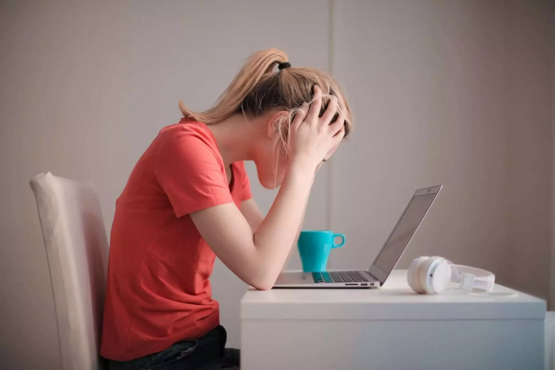 Afbeelding van gefrustreerde vrouw achter laptop
