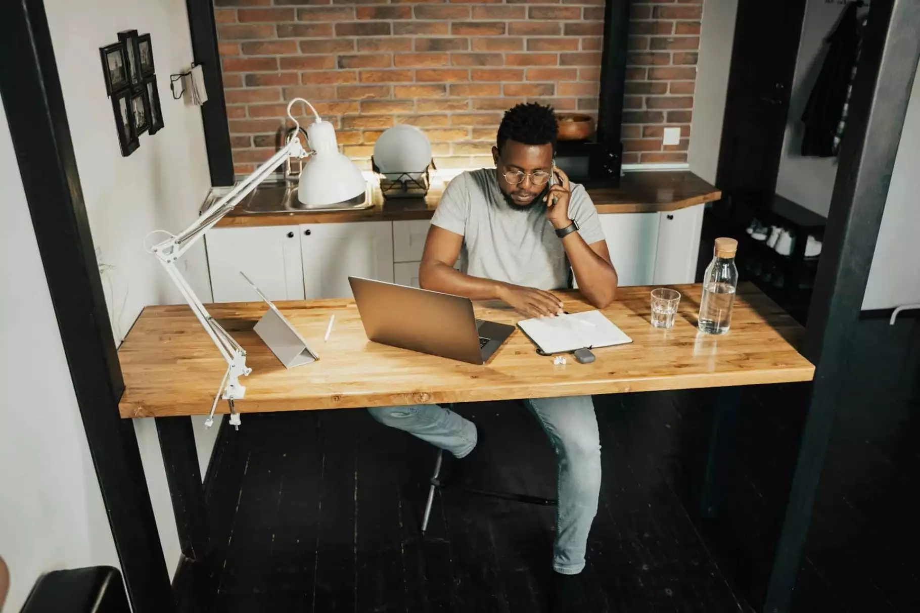Man zit bellend achter bureau met laptop