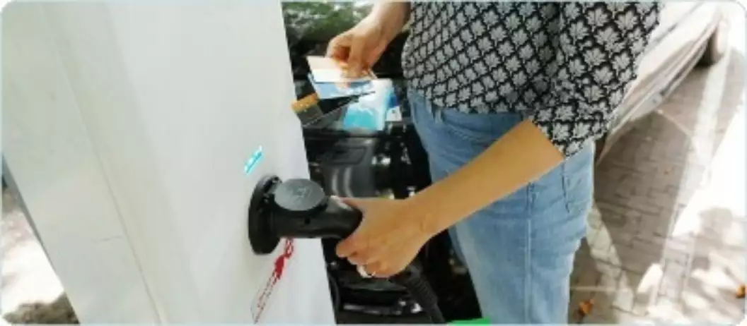 Vrouw laad elektrische auto op