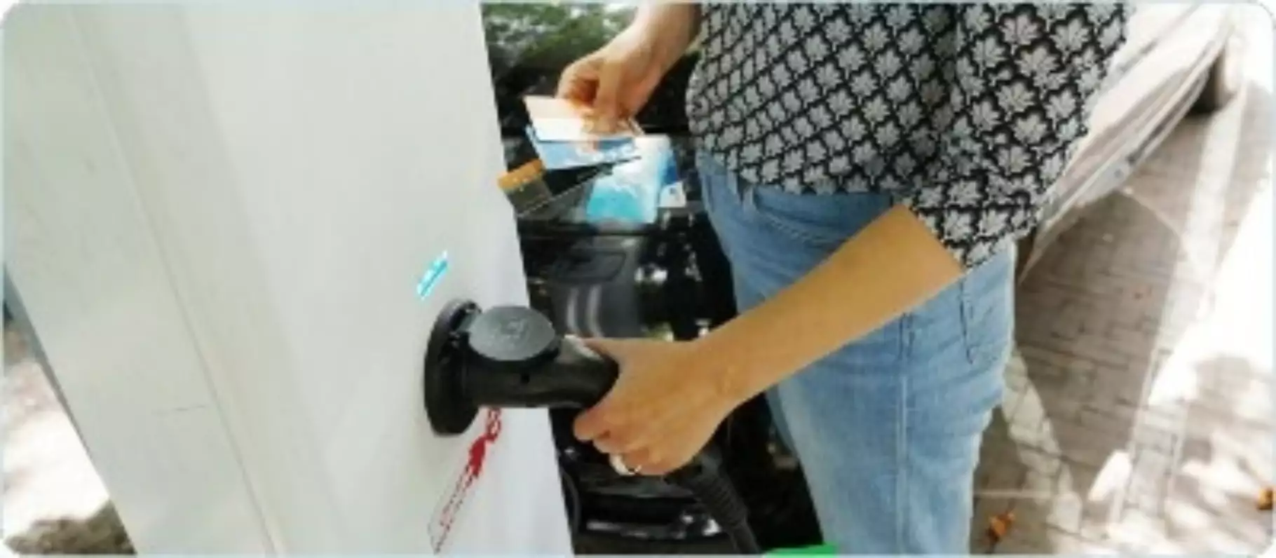 Vrouw laad elektrische auto op Vrouw laad elektrische auto op